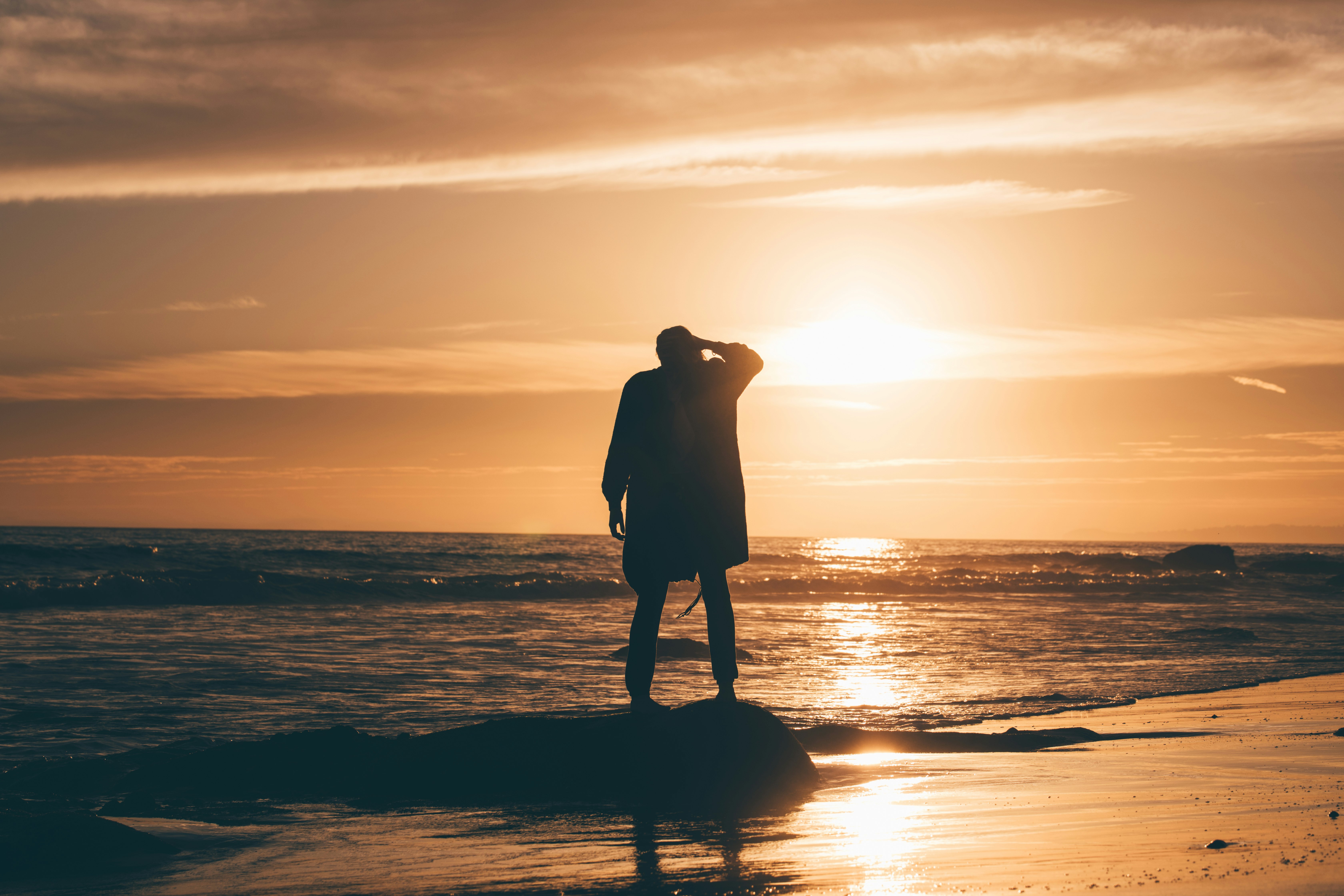 silhouette of person standing on body of water